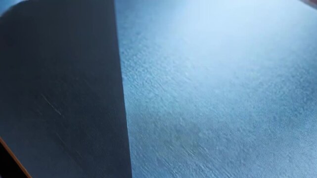 Industrial metal surface showcasing sharp angles and reflective edges, creating an abstract and contemporary composition with gradient color background
