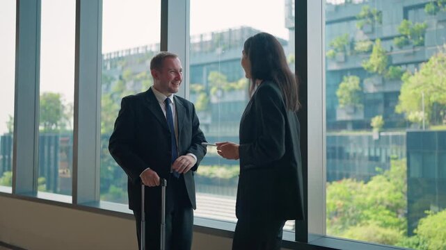 Business Meeting: A businessman and businesswoman engage in a lively conversation, set against the backdrop of modern architecture. This image reflects professionalism, collaboration.