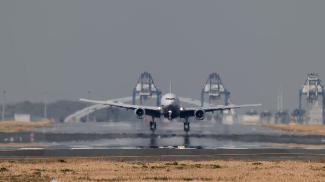 陽炎が立ち上がる滑走路から飛び立つ飛行機