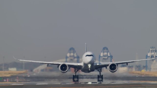 陽炎が立ち上がる滑走路から離陸する飛行機
