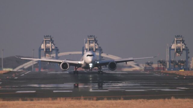 陽炎が立ち上がる滑走路に着陸する飛行機