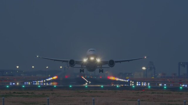夜の滑走路から飛び立つ飛行機