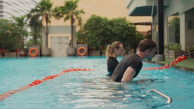Two people doing aqua biking in a pool at a modern wellness center, engaging in low-impact cardio, hydrotherapy, and mindful fitness, blending luxury wellness, active recovery, and holistic health tre