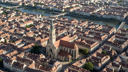 Obraz premium Aerial view of a historic town with a church and river flowing through residential buildings