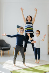 Fototapeta premium Family jumping, doing fitness exercise at home