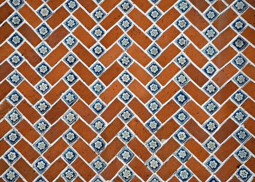 Handmade Terracotta and blue Talavera tiles symmetrical pattern with white accents on a Colonial building exterior wall in Puebla de Zaragoza, Mexico.