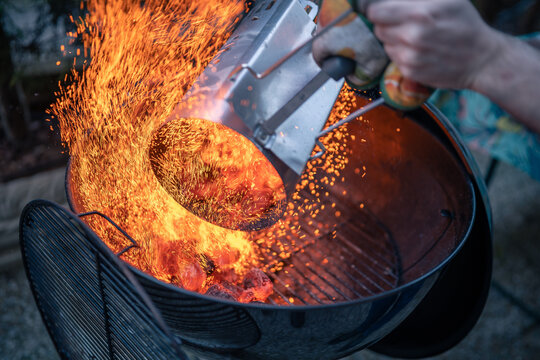 Close up on braces inside a BBQ ready to cook, sparks are visible.