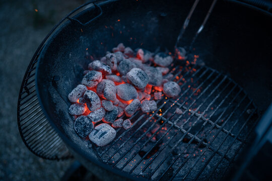 Close up on braces inside a BBQ ready to cook, sparks are visible.