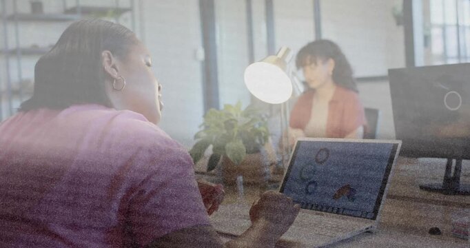 Primary woman pausing typing, gesturing while explaining laptop circles and house icon for business