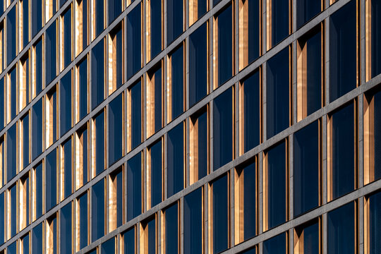 Repeating grid windows on a modern urban facade in warm light with clean lines and contemporary architecture creating abstract exterior texture