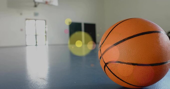 Orange basketball resting on blue court camera pulling back bokeh drifting over ball for sports