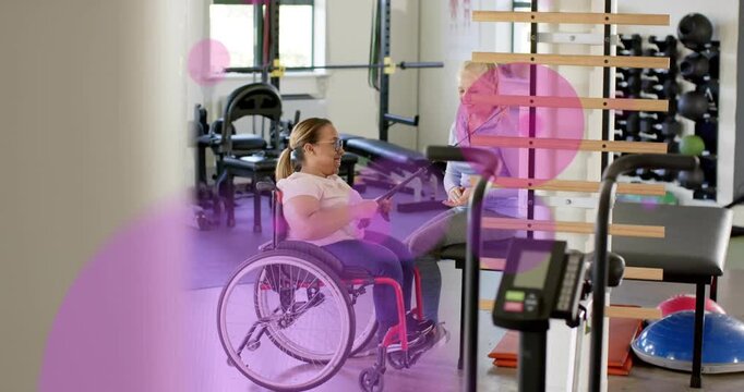 Patient in wheelchair rowing on therapist cue in rehab, magenta circles overlaying scene