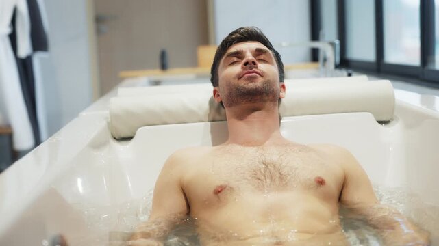 Man relaxing in a warm bath after a massage at a luxury wellness center, embracing post-treatment recovery, mindful self-care, hydrotherapy, slow living, emotional reset, and modern spa rituals