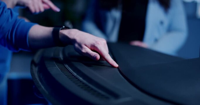 Close up of hand pointing at a gap in a black automotive dashboard during a quality control inspection