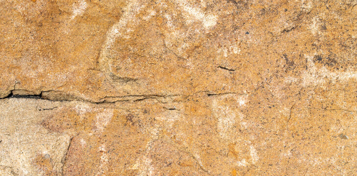 Top view of solid natural sandstone surface with rough grainy texture and horizontal crack showing detailed weathered geological pattern for construction background