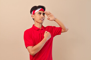 Fototapeta premium Indonesian man standing respectfully giving salute gesture in indonesia showing patriotism and pride during independence day or national ceremony