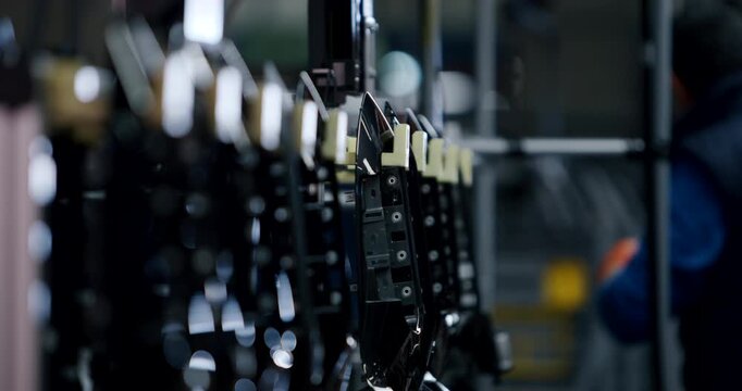 Row of black plastic automotive interior components on an automated assembly line in a factory