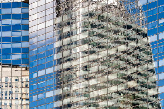 Glass facade reflections add modern texture to corporate business finance architecture at La Defense Paris with a contemporary office district building surface detail