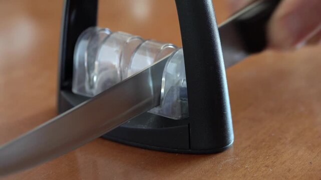 Sharpening a long kitchen knife closeup. Real time 4k resolution video