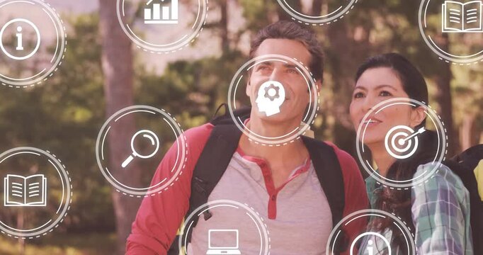 Hiking couple watching floating education icons, animated AR overlay appearing to map trail info