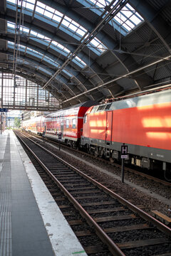 Interior platform at Berlin station with train in motion captures railway transport commute in Germany during daylight rush hour today