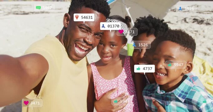 Man taking selfie while family posing on beach, animated icons popping up driving marketing reach