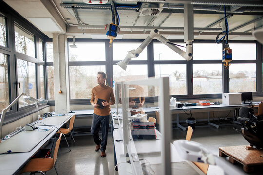 Mature engineer walking at workshop