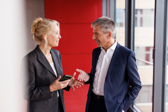 Senior businessman talking with colleague at work place