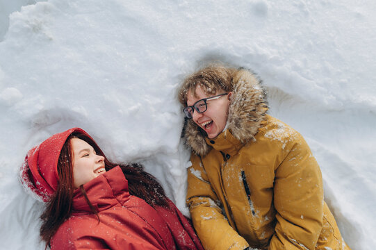 Couple enjoying winter romance and laughing in snowy forest
