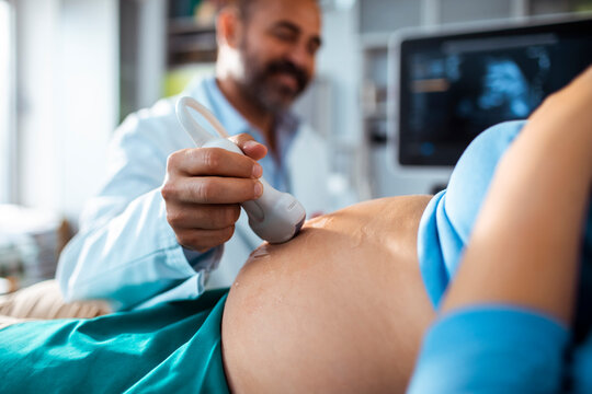 Doctor performing prenatal ultrasound on pregnant woman in clinic