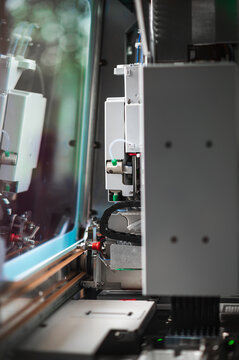 Extreme Closeup Pick And Place Head, Nozzle Descending Toward Circuit Board Under Focused Industrial Lighting,