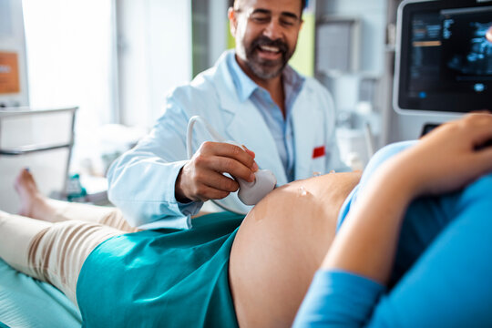 Doctor performing prenatal ultrasound on pregnant woman in clinic