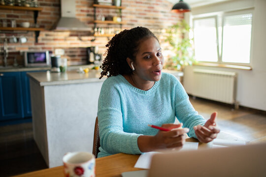 Woman on video call working from home in kitchen