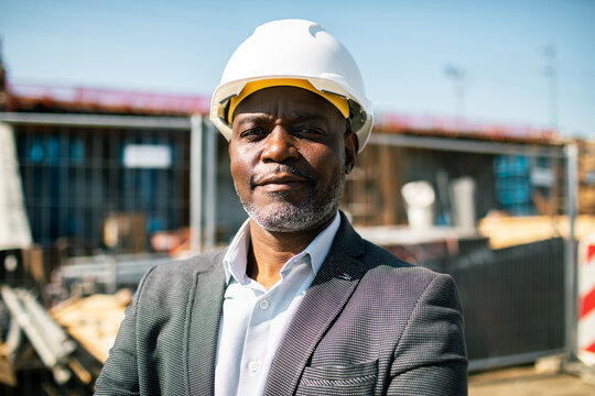 Confident construction manager wearing hard hat at building site