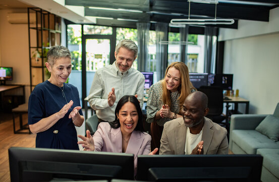 Diverse coworkers celebrating success at modern office