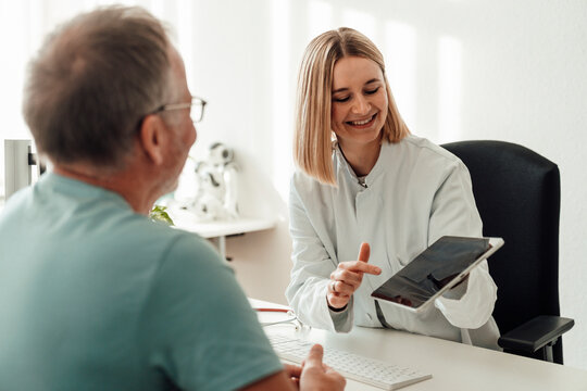 Doctor showing tablet to patient at hospital consultation