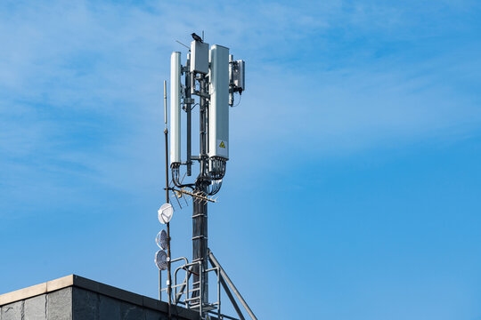 Cell tower stands tall against blue sky on a sunny day