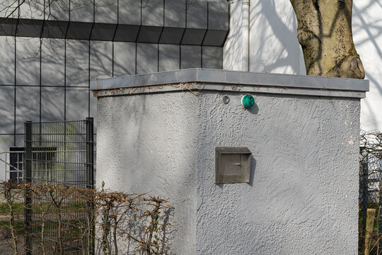 Small concrete structure near a building and a fence in the city