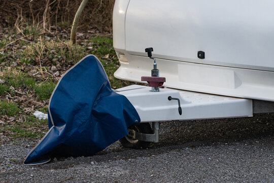 Trailer hitch with cover on a parking lot near trees