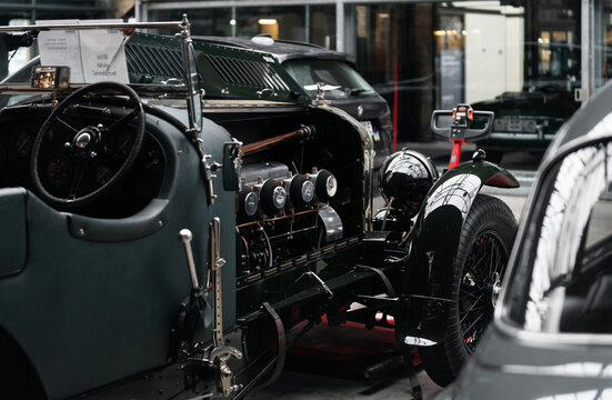 Bentley Speed 8 with exposed straight-eight engine in workshop. Vintage dark green Bentley Tourer with wire wheels and a retro cockpit with opened hood. Berlin, Germany - January 14 2026