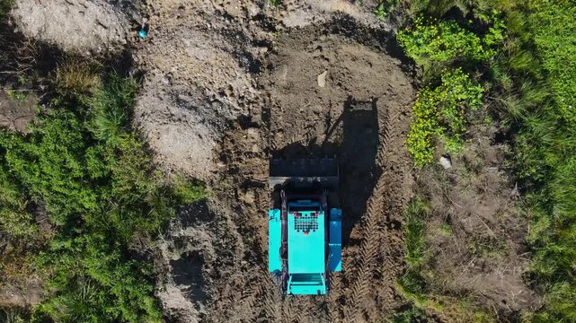 Aerial top view of a mini bulldozer leveling ground