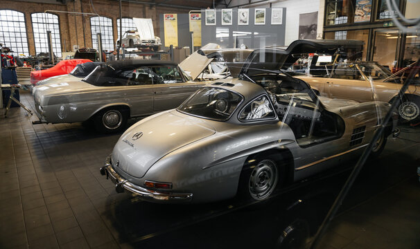 Vintage Mercedes-Benz cars in auto repair workshop. A line of old Mercedes-Benz models, including 300SL and W111 Cabriolet undergoing repairs and maintenance. Berlin, Germany - January 14 2026