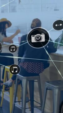Vertical video: Woman at counter, left dot appearing sparking cam, music icons over back for tech