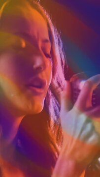 Vertical video: Prism sweep starting lead singer turning, tucking hair, raising mic for singing