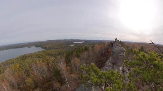 Picturesque rock formation in autumn. A majestic rock formation with a panoramic view of the surrounding mixed forest and lake.