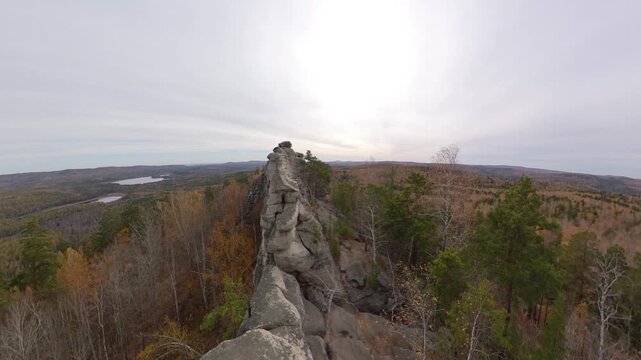 Picturesque rock massif in autumn. A majestic rock ridge with a panoramic view of the surrounding mixed forest and lake.