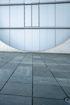 Minimal urban wall made of concrete tiles beside pavement showing simple geometry in daylight with an empty look and balanced copyspace for layouts