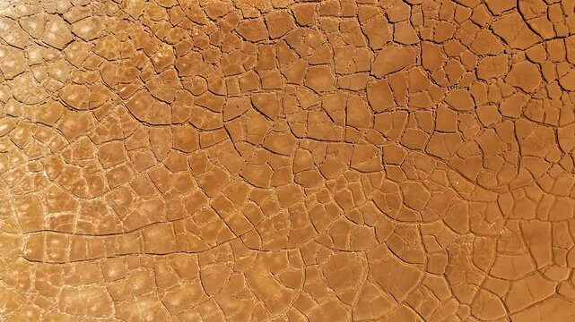 Aerial view of cracked red earth and dry mud patterns in the mining landscape of Minas de Riotinto, Andalusia, Spain.