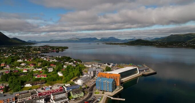 Stokmarknes, Norway, showing a coastal town, modern waterfront architecture and calm fjord scenery. Ideal for travel and landscape themes, cinematic aerial reveal