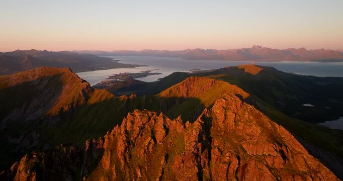 Aerial view of illuminated Storheia mountain peaks at sunset, Stokmarknes